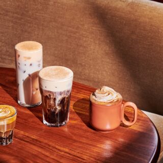 New Menu: Starbucks Pumpkin Spice Latte, Pecan Cortado, Pumpkin Spice Cold Brew and Pumpkin Spice Chai Latte in glasses on a wooden table