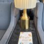 The Bright Hour: The book sitting on a table in the foreground with a brass lamp in the background between two chairs