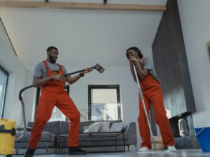 Cleaning Business: Man and woman cleaning in orange jumpsuits and playfully smiling at one another