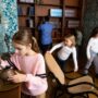 Escape Room: Interested tween girl examining ancient kettle in quest room stylized as old library