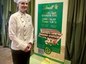 Dubai Style Chocolate Bar: Lindt's Maître Chocolatier next to a large mock up of the chocolate bar package