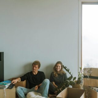 Moving with Pets: Couple sitting on the floor with their dog surrounded by boxes