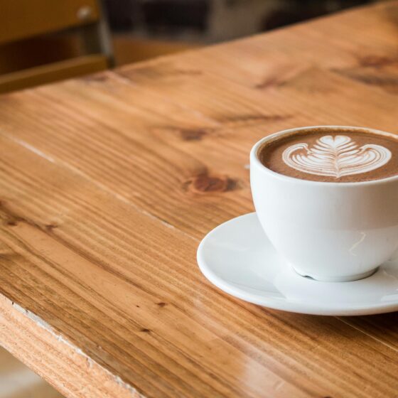 Coffee Breaks: Latte in a cup with saucer on a table