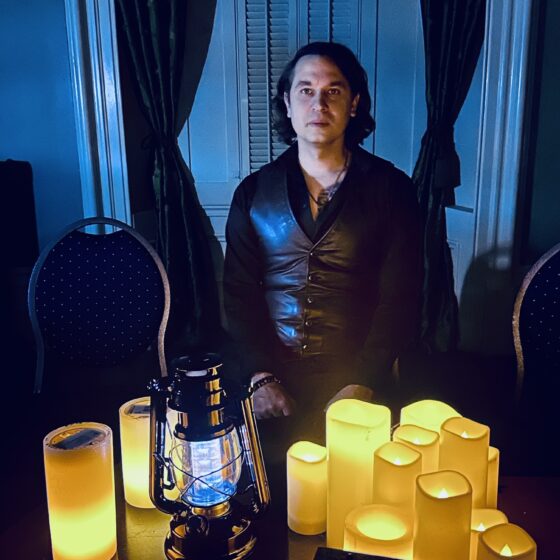 Beverley Street Séance RESURRECTION: Jaymes White in front of electric candles and lanterns