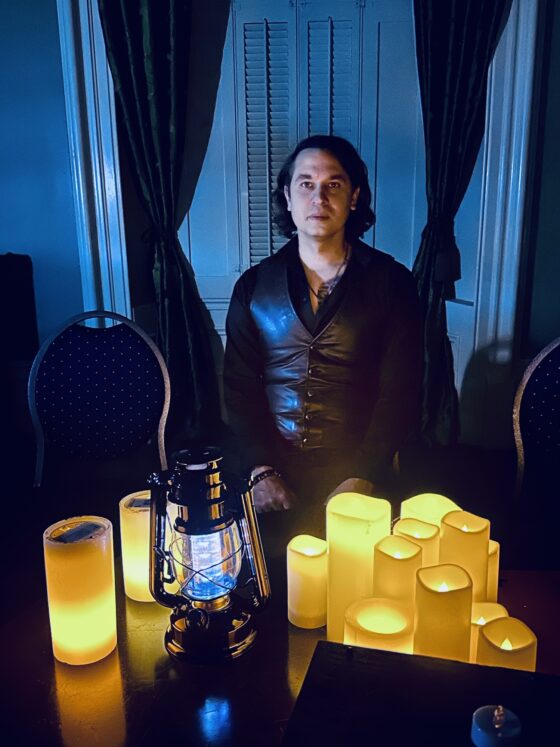 Beverley Street Séance RESURRECTION: Jaymes White in front of electric candles and lanterns