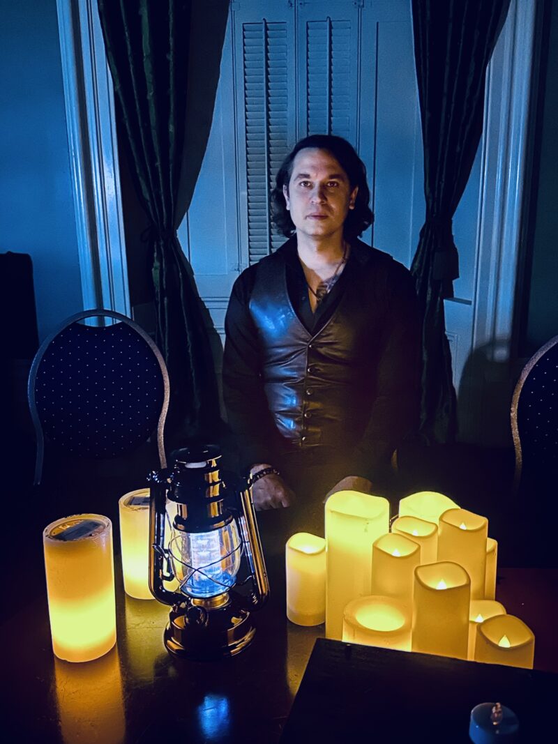 Beverley Street Séance RESURRECTION: Jaymes White in front of electric candles and lanterns