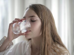 Water Bottle: Woman drinking water from a glass