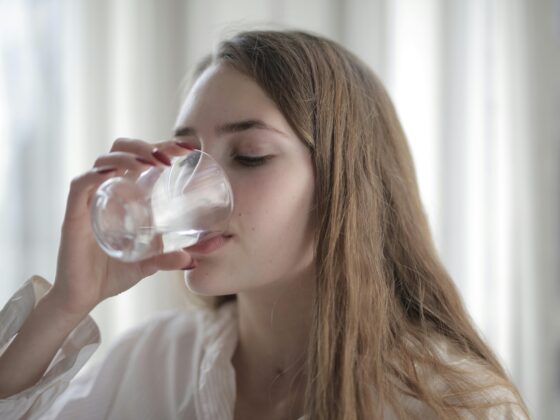 Water Bottle: Woman drinking water from a glass