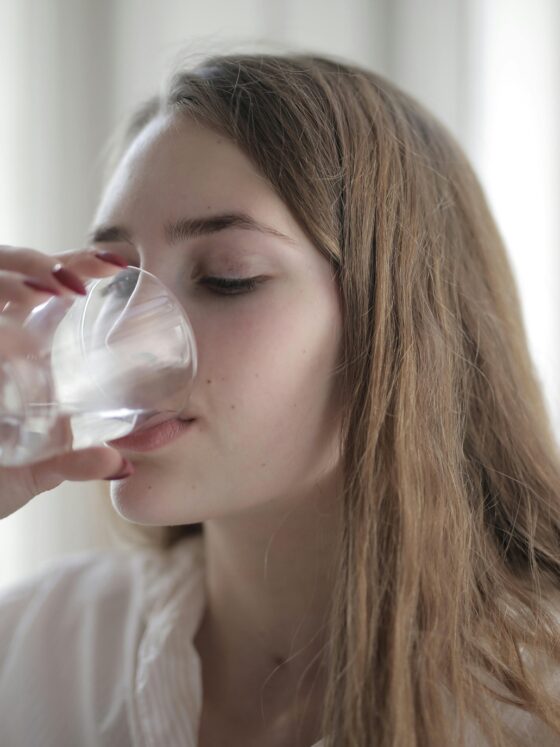 Water Bottle: Woman drinking water from a glass