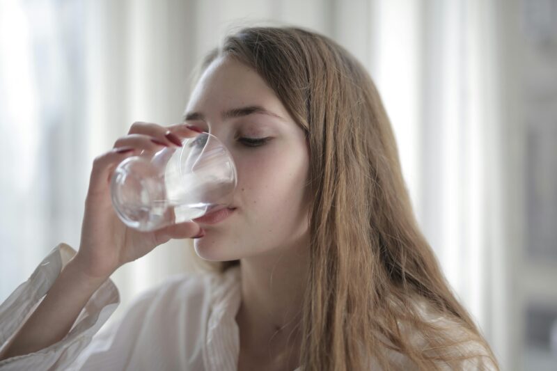 Water Bottle: Woman drinking water from a glass