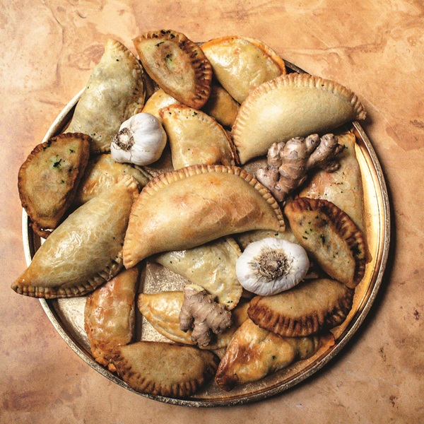 Empanadas: Plate of Tikka Masala Empanadas with ginger and garlic on top