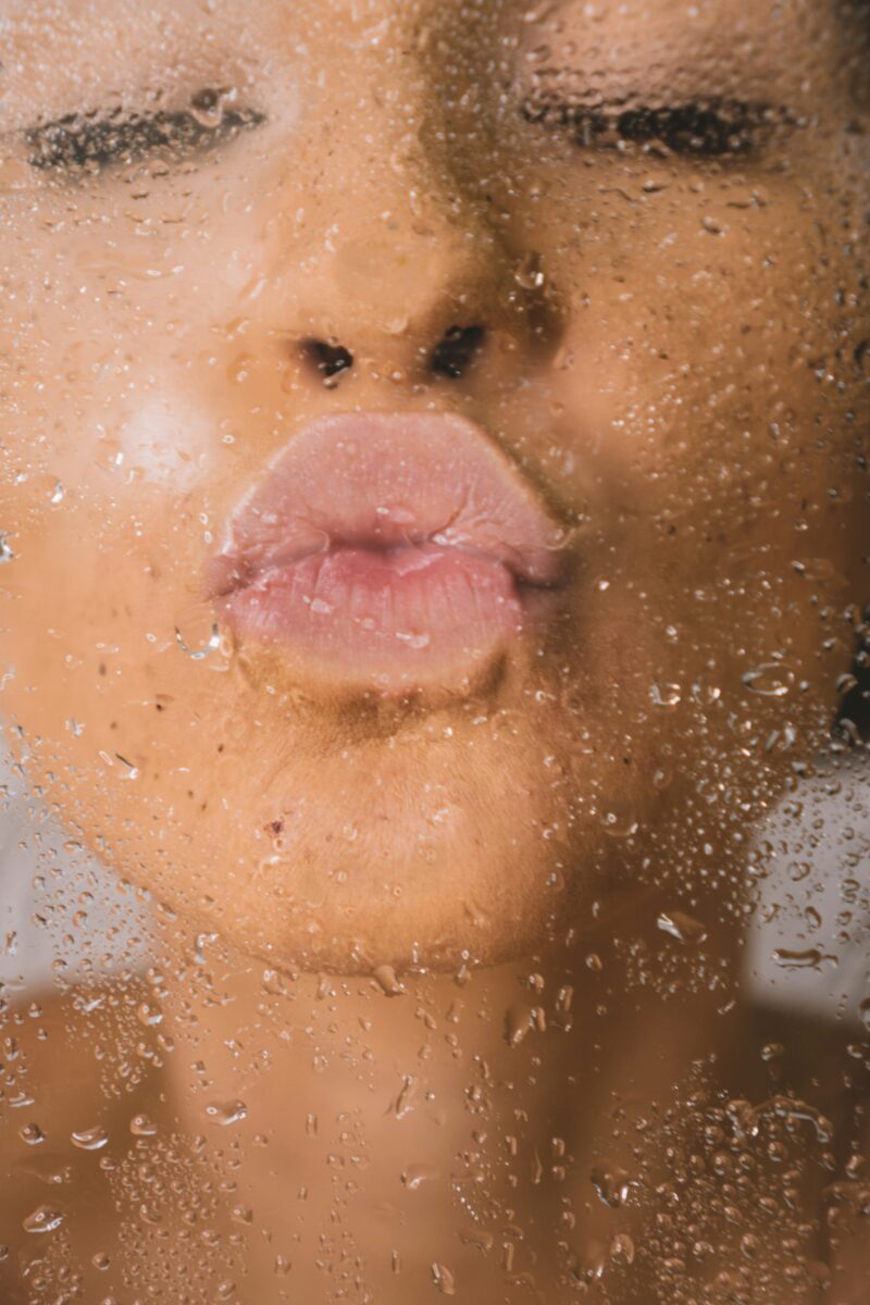 Anti-Aging Essentials: Woman puckering her lips on wet glass