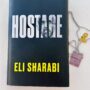 Hostage by Eli Sharabi: Book with hostage tag and hostage pin next to it