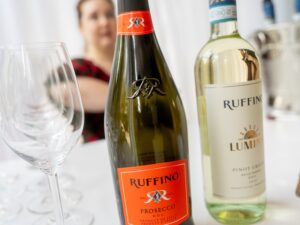 Prosecco: A bottle of Ruffino Prosecco and a bottle of Pinot Grigio on a table in the foreground with a person in the background