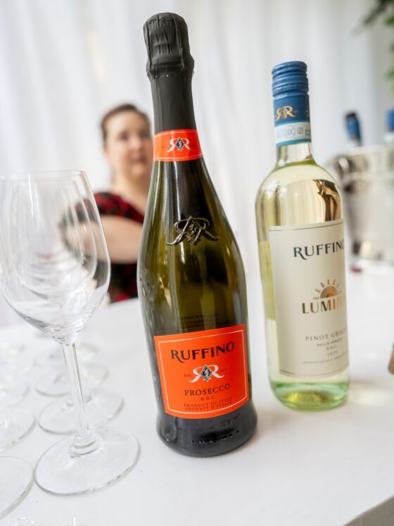 Prosecco: A bottle of Ruffino Prosecco and a bottle of Pinot Grigio on a table in the foreground with a person in the background
