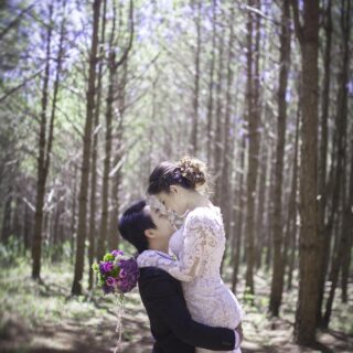 Wedding Photography: Couple in wedding attire embracing in the woods