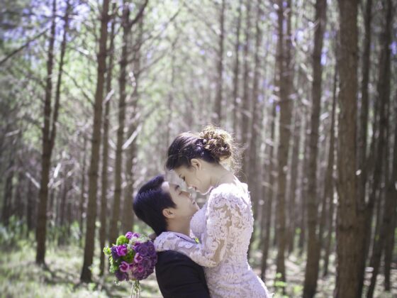Wedding Photography: Couple in wedding attire embracing in the woods