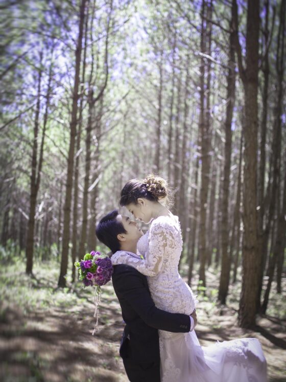 Wedding Photography: Couple in wedding attire embracing in the woods