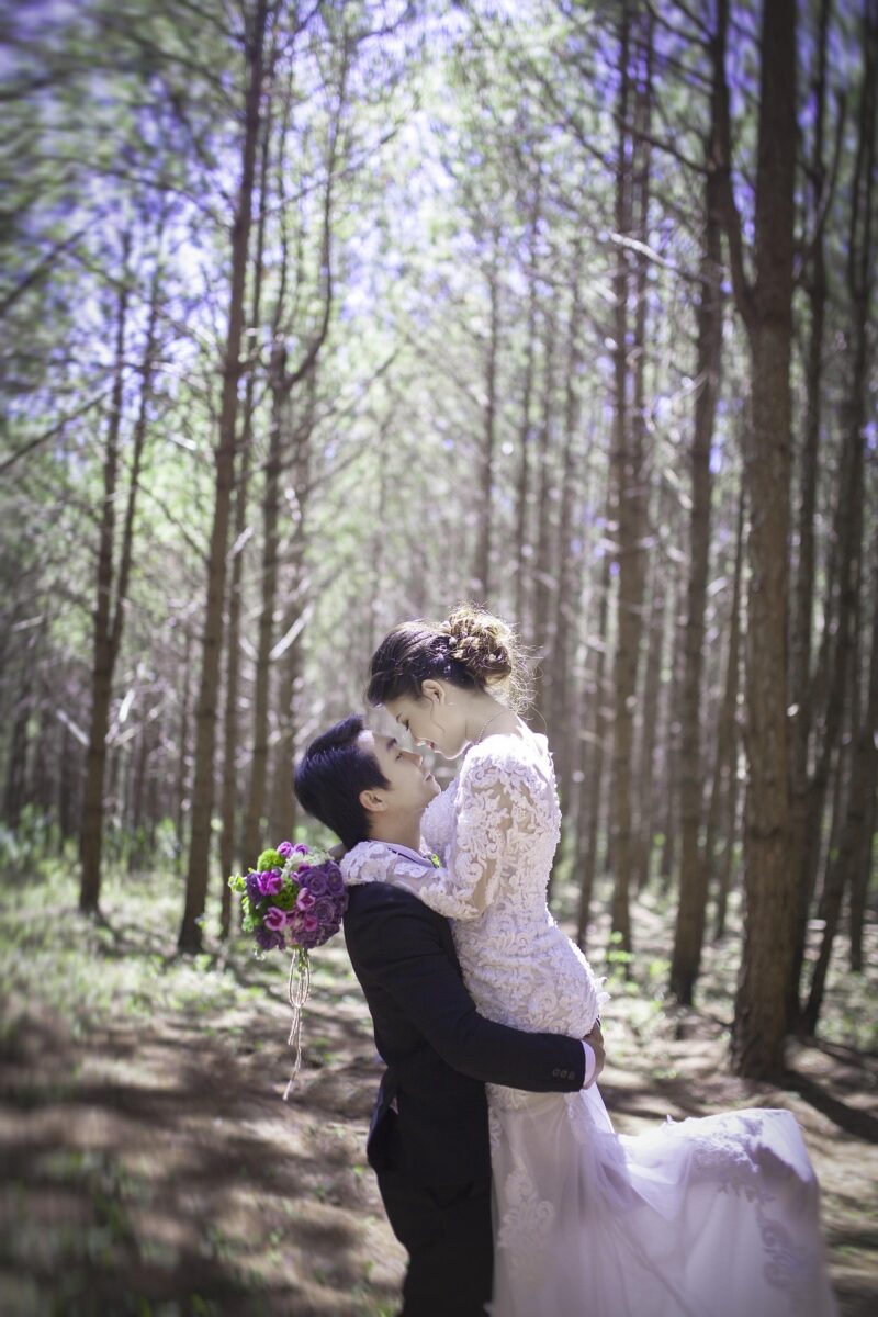 Wedding Photography: Couple in wedding attire embracing in the woods