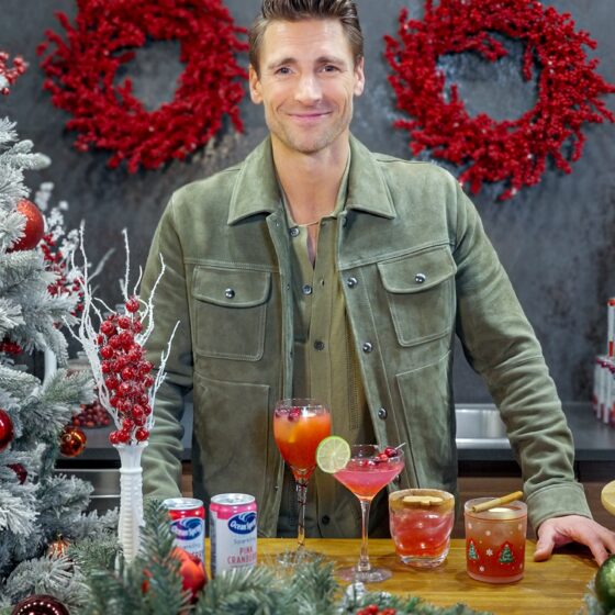 Holiday Ritual: Actor Andrew Walker behind a bar that is decorated with holiday decor with Ocean Spray Cans and cocktails in front of him