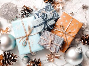 Gifts for Everyone on Your List: Holiday gifts beautifuly wrapped with pine cones and ornaments surrounding them