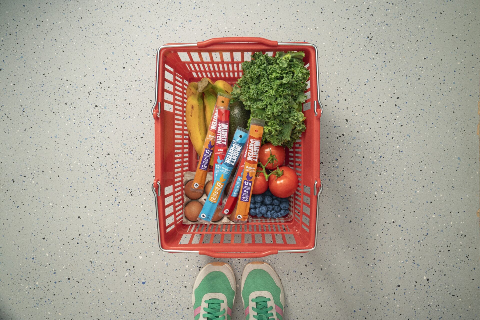 Protein for Women: Grocery basket with produce and Mighty Protein sticks next to women's sneakers