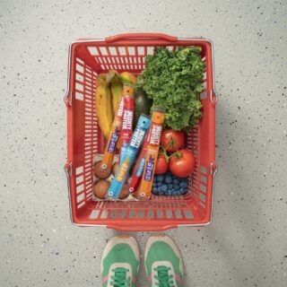 Protein for Women: Grocery basket with produce and Mighty Protein sticks next to women's sneakers