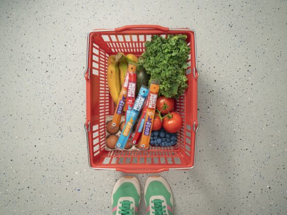 Protein for Women: Grocery basket with produce and Mighty Protein sticks next to women's sneakers