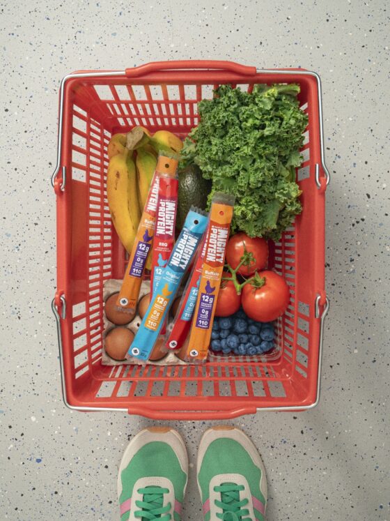 Protein for Women: Grocery basket with produce and Mighty Protein sticks next to women's sneakers