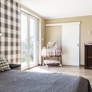 Nursery: Beige bedroom with a newborn's corner with crib on wheels