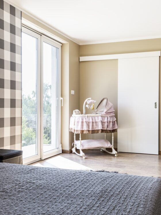 Nursery: Beige bedroom with a newborn's corner with crib on wheels