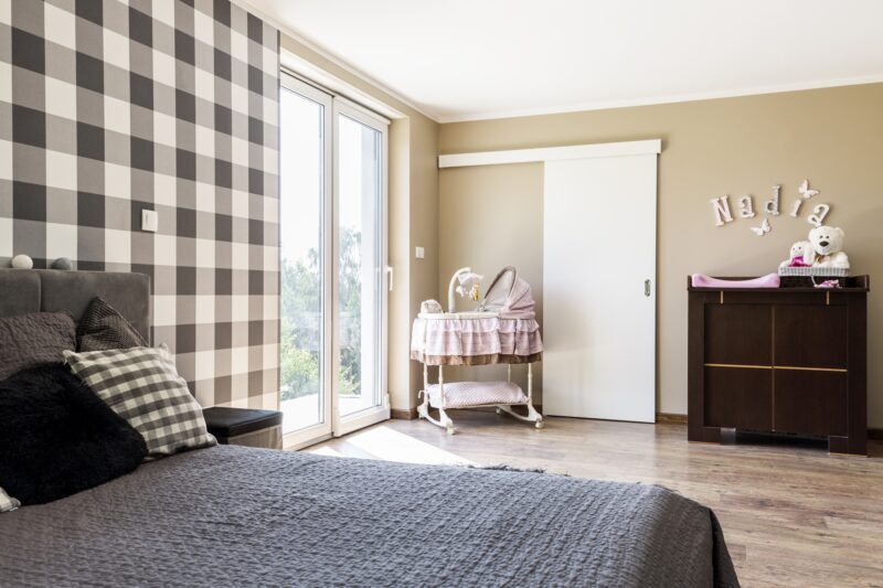 Nursery: Beige bedroom with a newborn's corner with crib on wheels