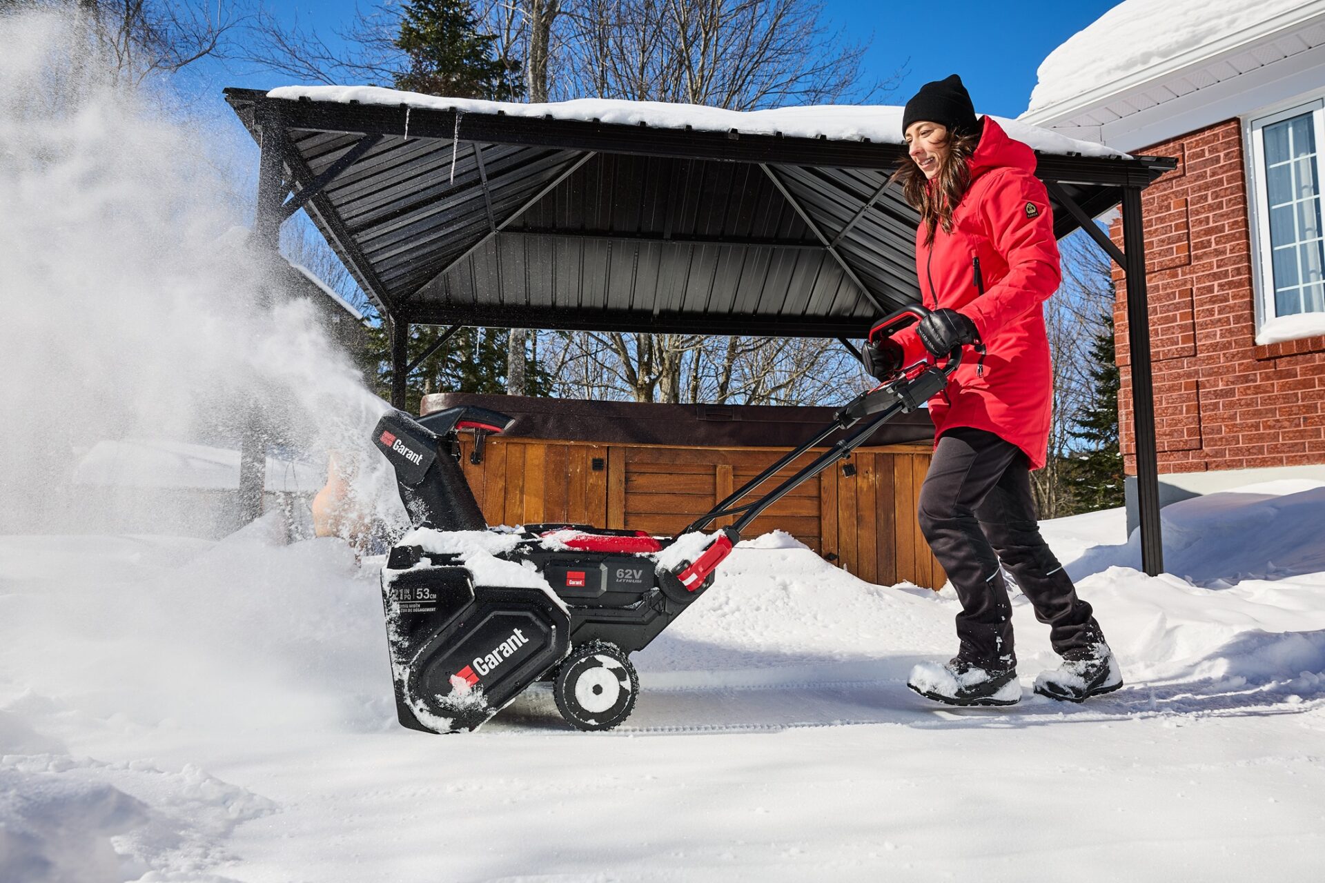 Snow Blowers: Woman pushing snowblower in front of her home