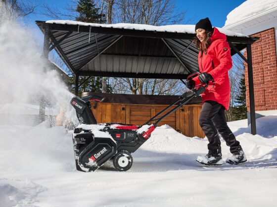 Snow Blowers: Woman pushing snowblower in front of her home