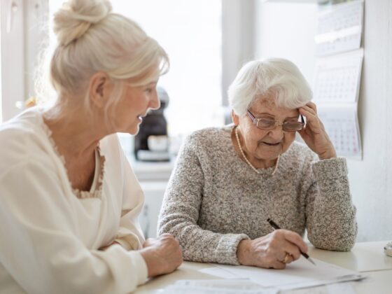 Caring for aging parents: Woman helping her elderly mother preparing financial documents