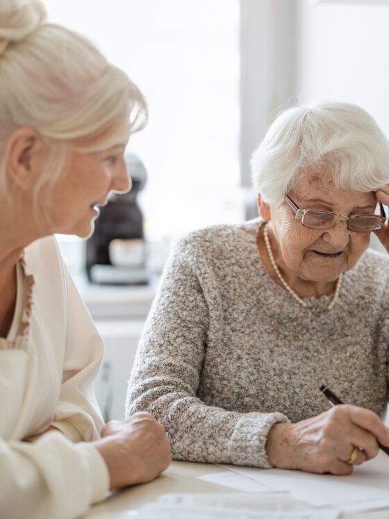 Caring for aging parents: Woman helping her elderly mother preparing financial documents