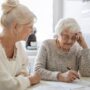 Caring for aging parents: Woman helping her elderly mother preparing financial documents
