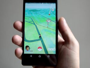 Online Entertainment: Hand holding a mobile device with a game on the home screen