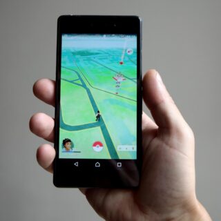 Online Entertainment: Hand holding a mobile device with a game on the home screen