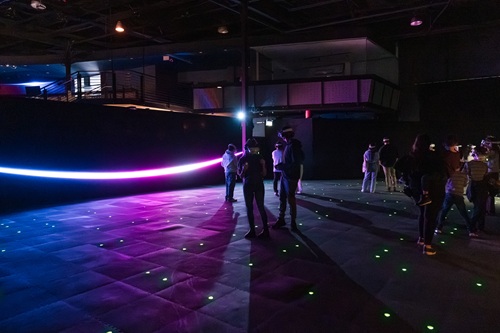 Space Explorers: THE INFINITE: People walking around a large room with VR goggles on