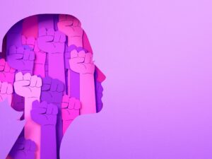 International Women's Day 2026: Pink graphic of a woman's head filled with rising fists.