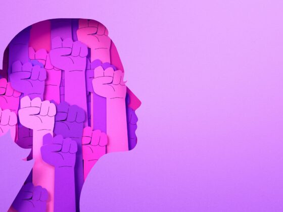 International Women's Day 2026: Pink graphic of a woman's head filled with rising fists.