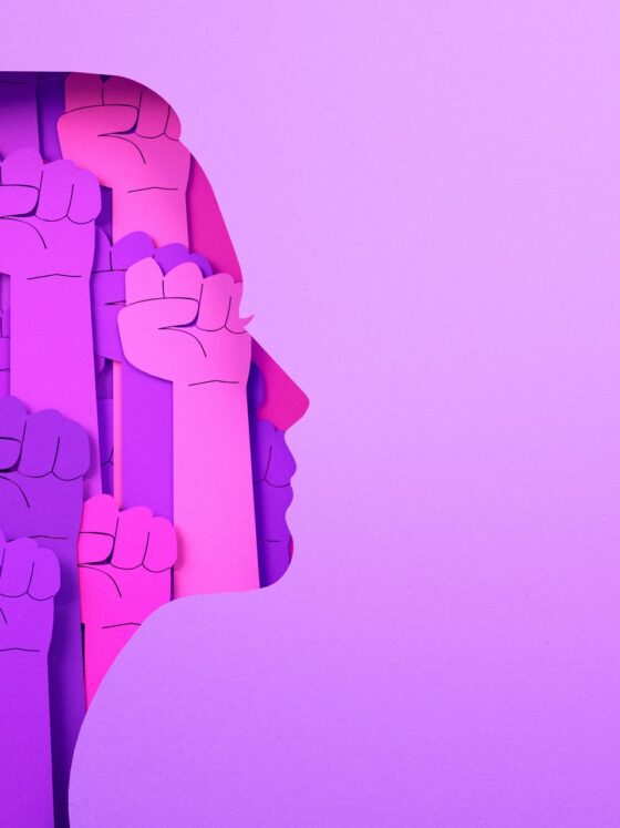 International Women's Day 2026: Pink graphic of a woman's head filled with rising fists.