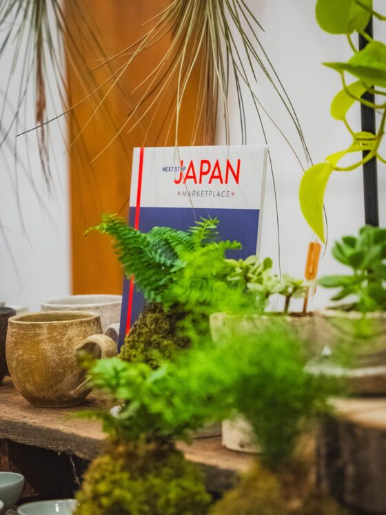 Japanese: Sign for Japan Marketplace surrounding by plants and pottery