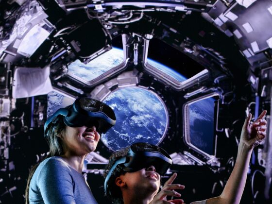 Space Explorers: The Infinite: Woman and Child with Space in the background wearing VR goggles
