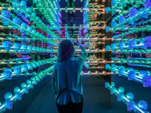 Art of the Brick: Woman in a room filled with blue lit LEGO Skulls