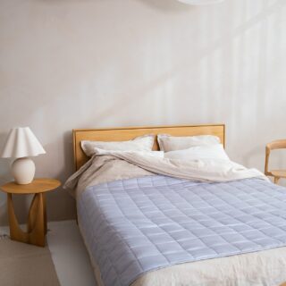 Duvet Cover: Bed with duvet cover on plus small table with lamp and chair