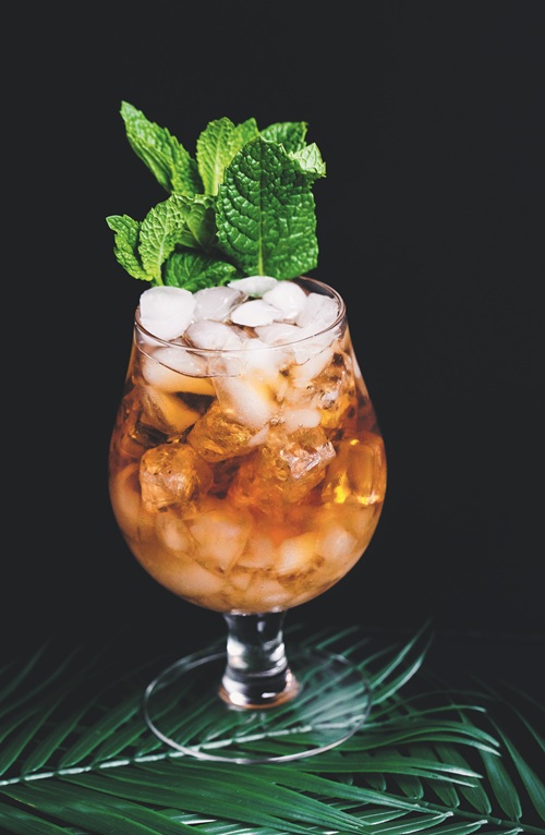 Beach Cocktails: Icy amber coloured cocktail in a stemmed glass garnished with mint