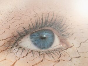 Eye Health: Double exposure of human eye in dry land on the background.