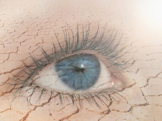 Eye Health: Double exposure of human eye in dry land on the background.